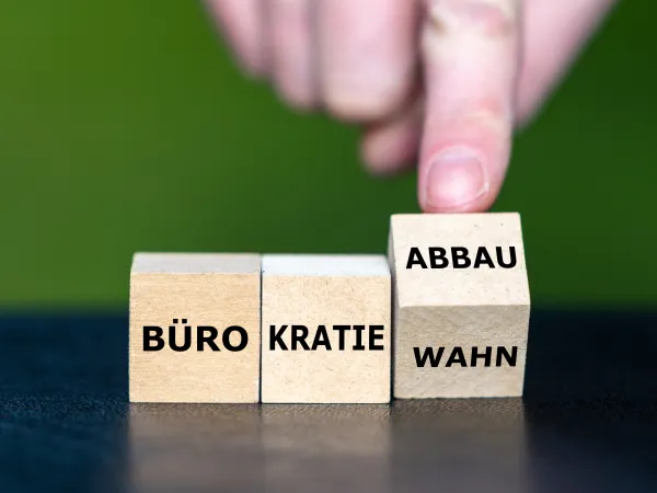 Drei Würfel mit der Aufschrift Bürokratie/Wahn/Abbau 